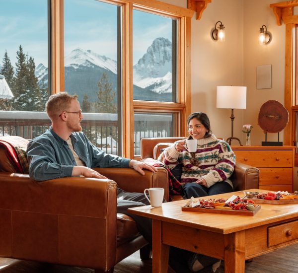 A couple enjoying afternoon tea in the lounge at Mount Engadine Lodge in Kananaskis, Alberta